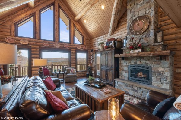 Living Room with Stone Fireplace and Log walls